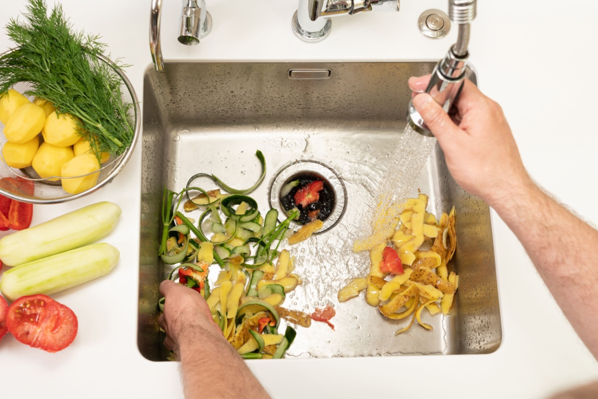 Potato peels and vegetable scraps in the kitchen sink after prepping veggies for dinner