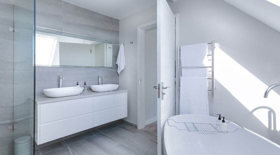 Modern bathroom with double sinks and bathtub.